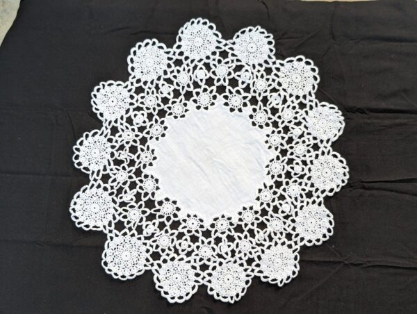 Vintage-style crochet lace centerpiece, white on black, floral motifs