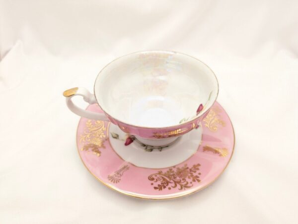 Elegant pink teacup & saucer with rose pattern, gold accents. Vintage collectible