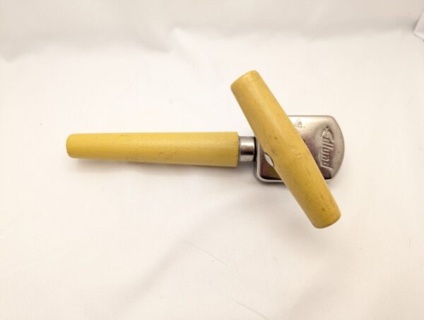 Vintage yellow wooden can opener with silver top