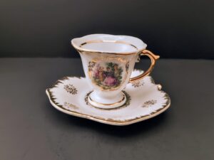 Victorian tea cup and saucer with purple florals, gold trim, on maple leaf plate